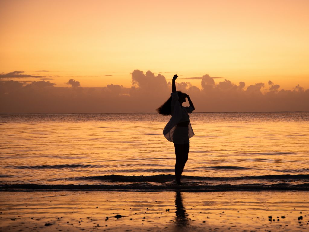 Zanzibar beach at sunset with silhouette walking along the Indian Ocean